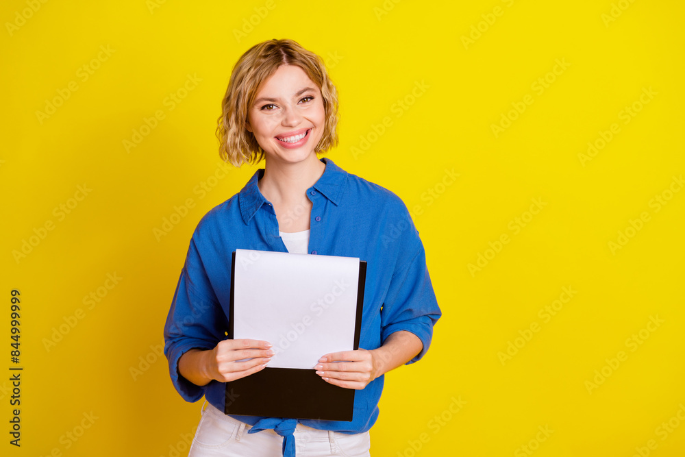 Portrait of pretty young lady clipboard empty space wear blue shirt isolated on yellow color background Portrait of pretty young lady clipboard empty space wear blue shirt isolated on yellow color background