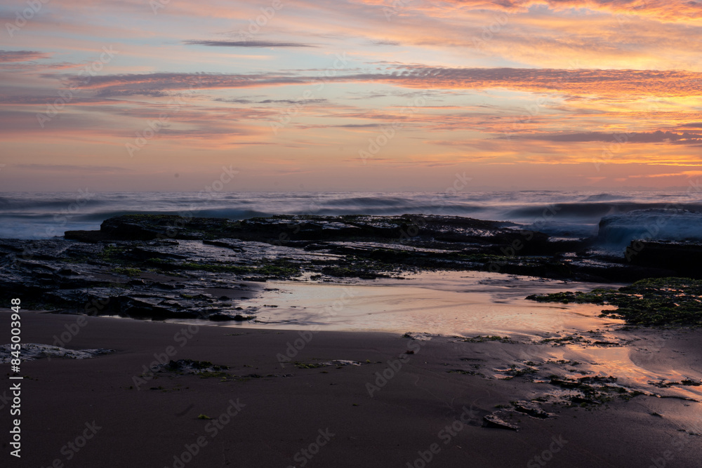 Sunrise over breaking waves beach orange yellow clouds Sunrise over breaking waves beach orange yellow clouds