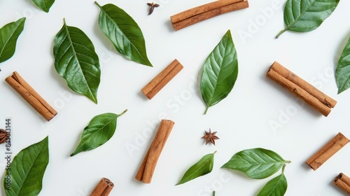Cinnamon sticks and green leaves are separate on a white background