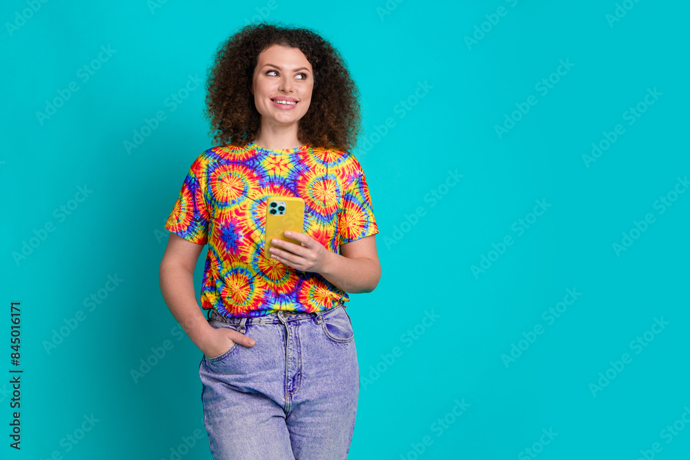Photo of adorable cute woman wear trendy print clothes use device look empty space isolated on cyan color background Photo of adorable cute woman wear trendy print clothes use device look empty space isolated on cyan color background