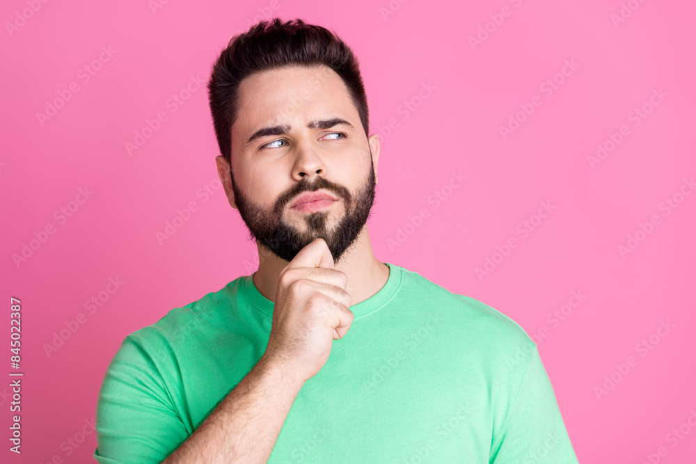 Photo of minded clever guy with stylish beard dressed green t-shirt look at proposition empty space isolated on pink color background Photo of minded clever guy with stylish beard dressed green t-shirt look at proposition empty space isolated on pink color background