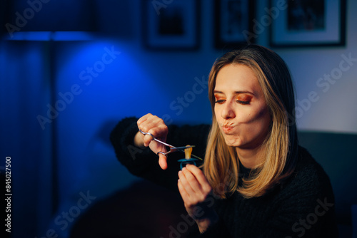 Fotografi Mother Cutting a Pacifier for Her Little Baby