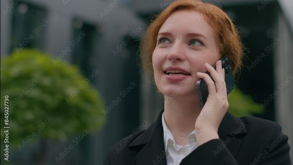 Close up smiling confident young ginger Caucasian woman girl female businesswoman suit pleasant business conversation talking mobile phone online call speak smartphone connection outside city downtown Close up smiling confident young ginger Caucasian woman girl female businesswoman suit pleasant business conversation talking mobile phone online call speak smartphone connection outside city downtown