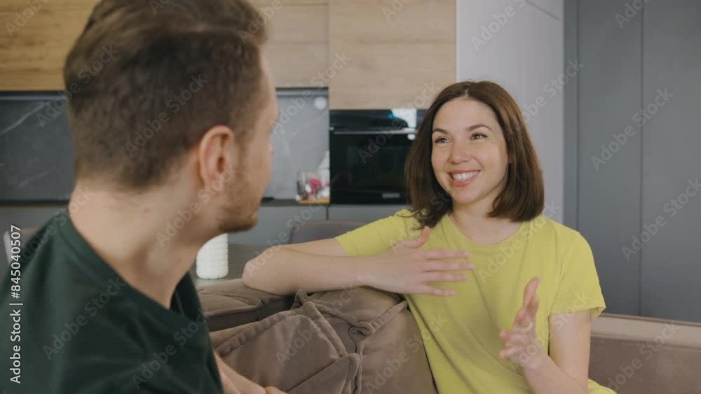 In a cozy modern home, a young couple is having a relaxed conversation on a comfortable sofa, a warm and connected atmosphere. They seem happy together in their living space In a cozy modern home, a young couple is having a relaxed conversation on a comfortable sofa, a warm and connected atmosphere. They seem happy together in their living space