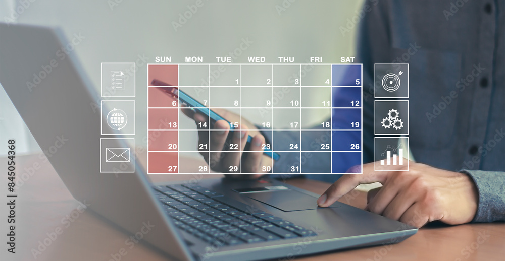 Fototapeta premium Businessman uses index finger to set agenda on calendar as appointment planning concept. 
