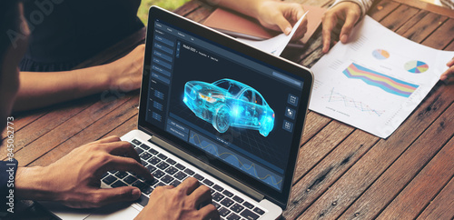 Electric car design software on computer screen showing simulation blueprint snugly by digital calculating application for manufacturing preparation