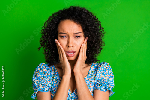 Portrait of pretty young woman arms touch cheeks wear top isolated on green color background