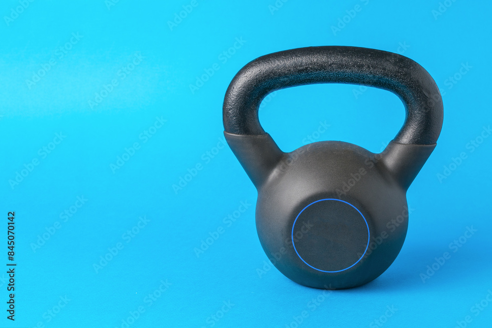 Black Kettlebell on Blue Background for Fitness and Strength Training Black Kettlebell on Blue Background for Fitness and Strength Training