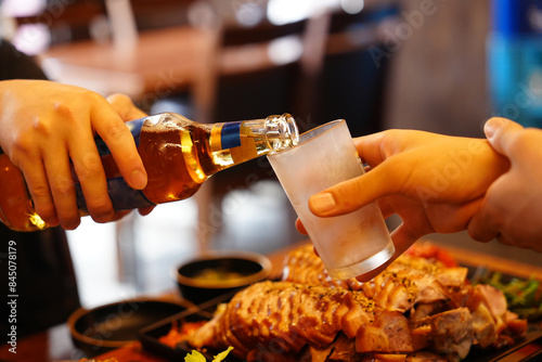 술자리에서 맥주를 상대편 잔에 따라 주느 모습