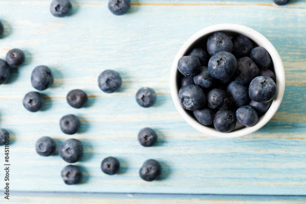 Ripe organic blueberries on blue wooden table background. Selective focus. Ripe organic blueberries on blue wooden table background. Selective focus.