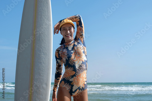 Photography Asian Female surfer warms up and stretches before going surfing in the sea, exer