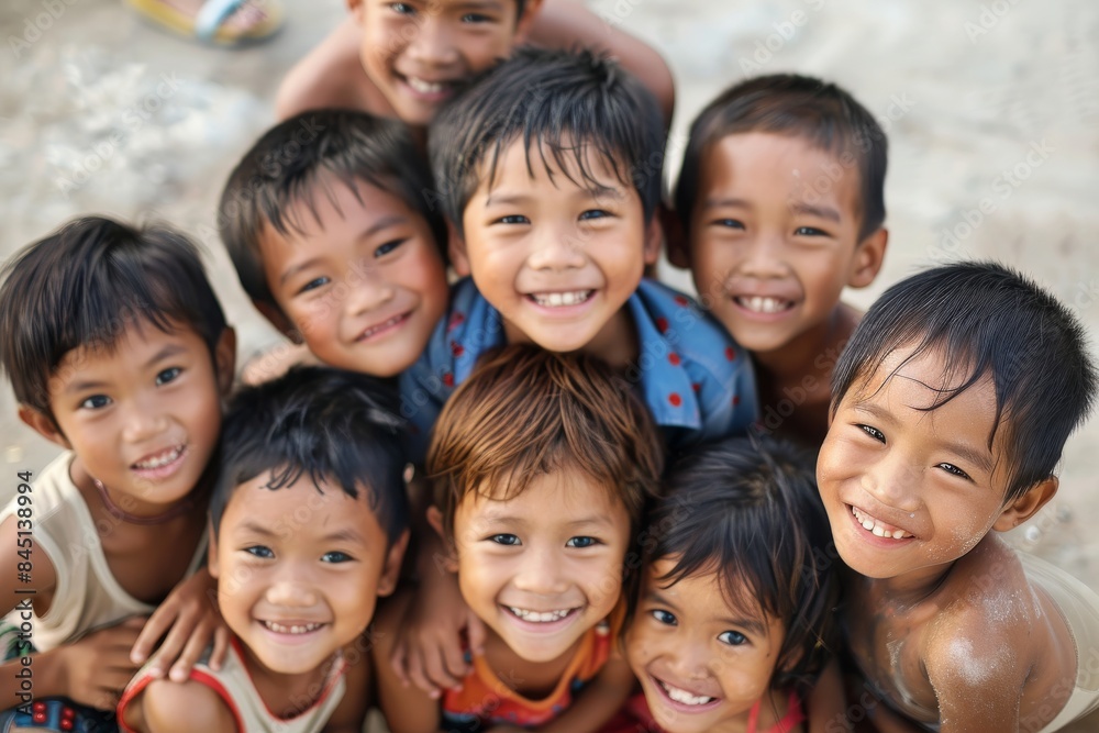 Group of Asian children smiling and looking at camera on the beach.