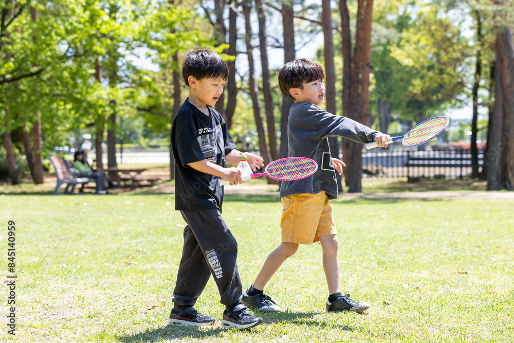 Obraz premium 公園でバトミントンを楽しむ子ども