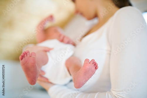 Mom holding newborn baby, looking at infant lovingly. Unconditional paternal love, Mother's Day concept.