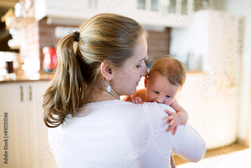 Canvas Print Mom holding newborn baby, looking at infant lovingly