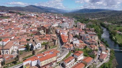 Picturesque aerial view of Plasencia city located in valley of Jerte river overlooking terracotta tiled roofs of residential buildings and medieval cathedral complex in spring, Extremadura, Spain photo