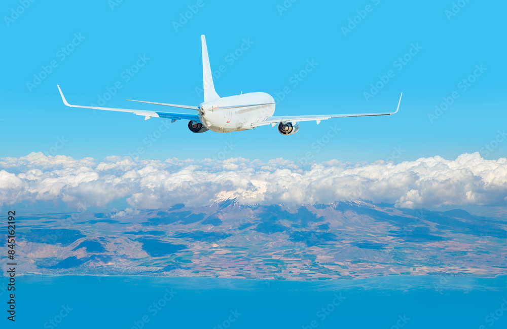 Airplane is flying over amazing snowy mountains and lake - White passenger airplane flying in the sky amazing clouds in the background - Travel by air transport Airplane is flying over amazing snowy mountains and lake - White passenger airplane flying in the sky amazing clouds in the background - Travel by air transport