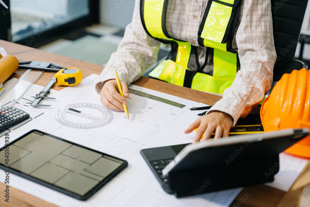 Businessman hand working and laptop with on on architectural project at construction site Businessman hand working and laptop with on on architectural project at construction site