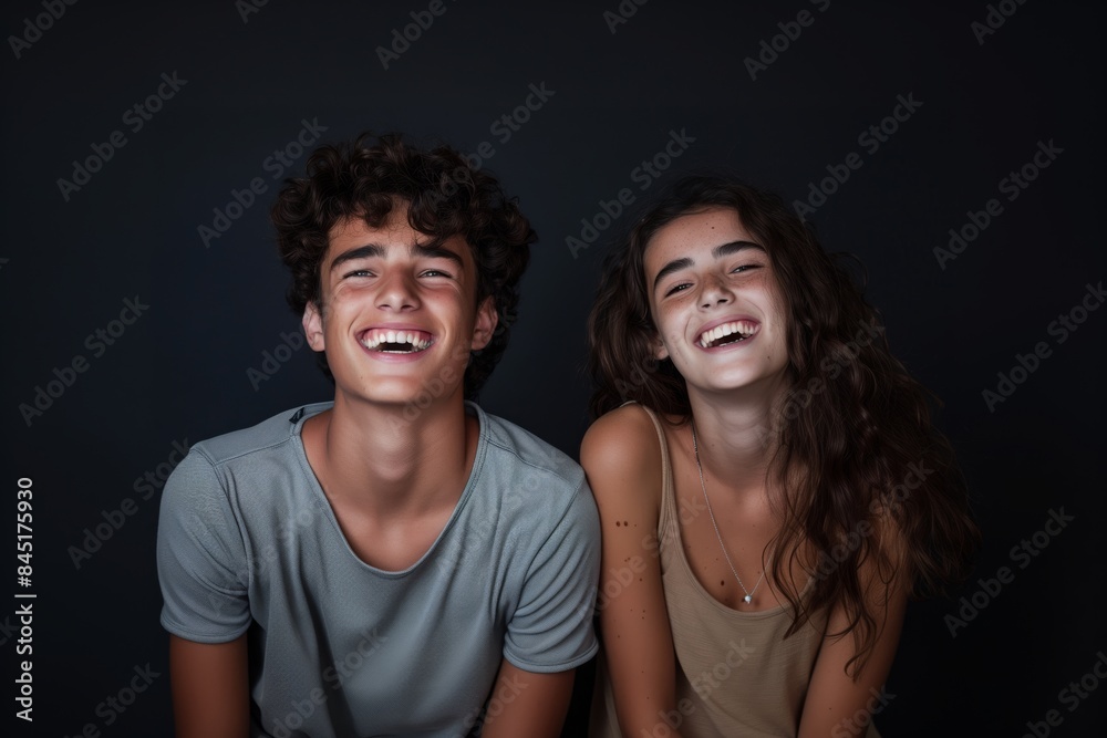 Two young adults laughing together in a studio