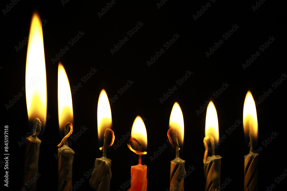 Lit Candles in a Row Against a Dark Background Emitting Warm Glow Lit Candles in a Row Against a Dark Background Emitting Warm Glow