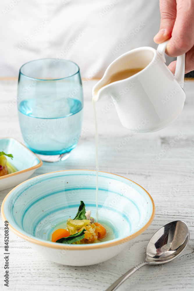 Fish soup with vegetables on white wooden table Fish soup with vegetables on white wooden table