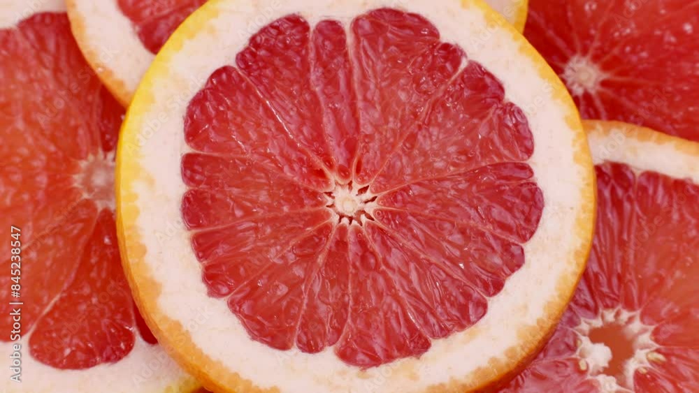 Bright pink and red grapefruit slices circle rotation close up Bright pink and red grapefruit slices circle rotation close up