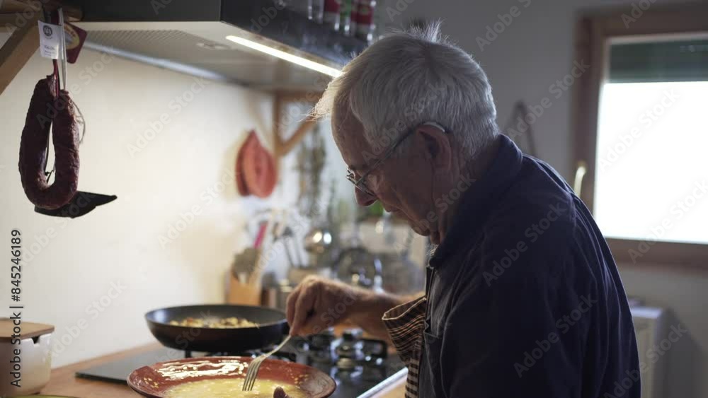 video of old man cooking an omelette of aubergine, retired and alone preparing dinner at home, tired and leaning. rustic wooden kitchen video of old man cooking an omelette of aubergine, retired and alone preparing dinner at home, tired and leaning. rustic wooden kitchen