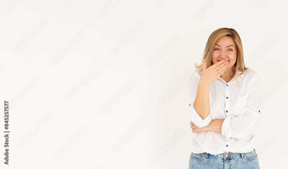 A pretty young woman covers her mouth with her hand while nervously laughing. Cute Caucasian girl giggles with her hand close to her lips. Concept of fun, pranks, joking around A pretty young woman covers her mouth with her hand while nervously laughing. Cute Caucasian girl giggles with her hand close to her lips. Concept of fun, pranks, joking around
