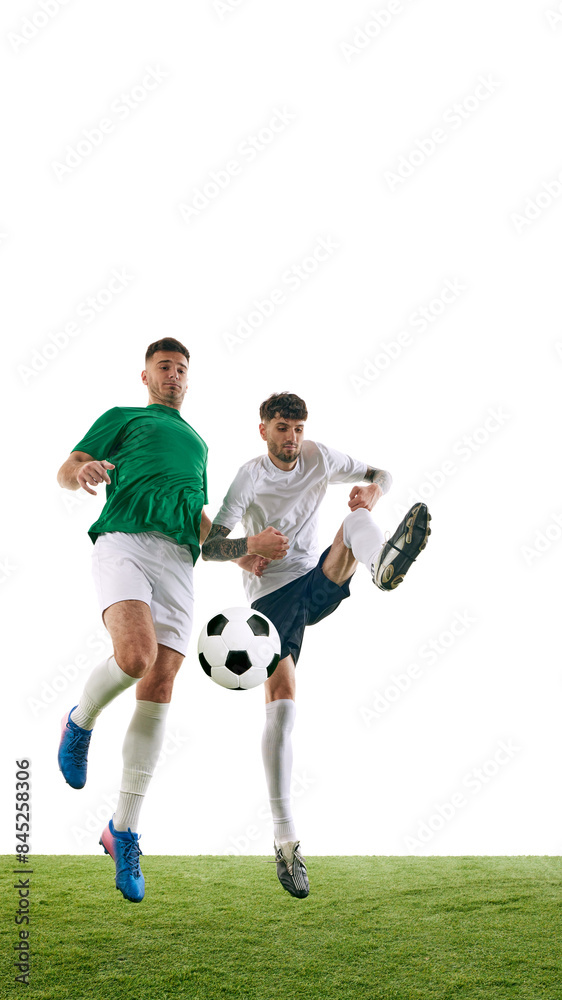 Dynamic photo of two soccer players playing football on green lash playground against white background. Intense moment during game. Concept of professional sport, championship, final match, movement. Dynamic photo of two soccer players playing football on green lash playground against white background. Intense moment during game. Concept of professional sport, championship, final match, movement.