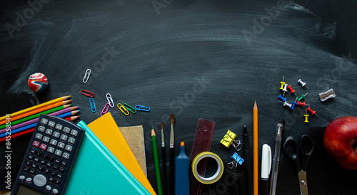School supplies on black board background. Back to school concept