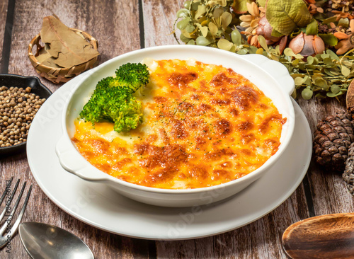 Creamy Bacon Gratin baked rice with broccoli spoon and fork served in plate isolated on wooden table side view of taiwan fasfood photo