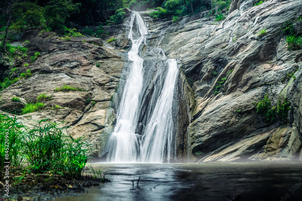 Obraz premium Smooth and long waterfall between rocks shot in high exposure and nobody around