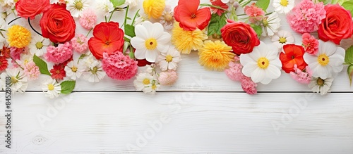 A copy space image featuring a variety of strawberries fresh ripe and underripe The strawberries along with their flowers and leaves are displayed on a white wood table background photo