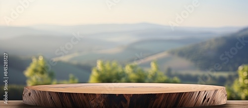 Fototapeta Naklejka Na Ścianę i Meble -  Wooden table with an empty perspective showcasing a mock up display set against a blurred landscape background A perfect copy space image for product representation concept