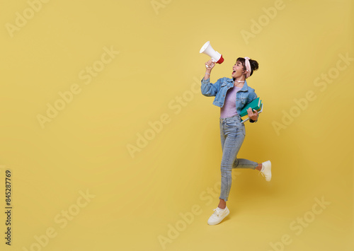 Принти на полотні Young Asian teen college student holding megaphone announce isolated on yellow copy space background