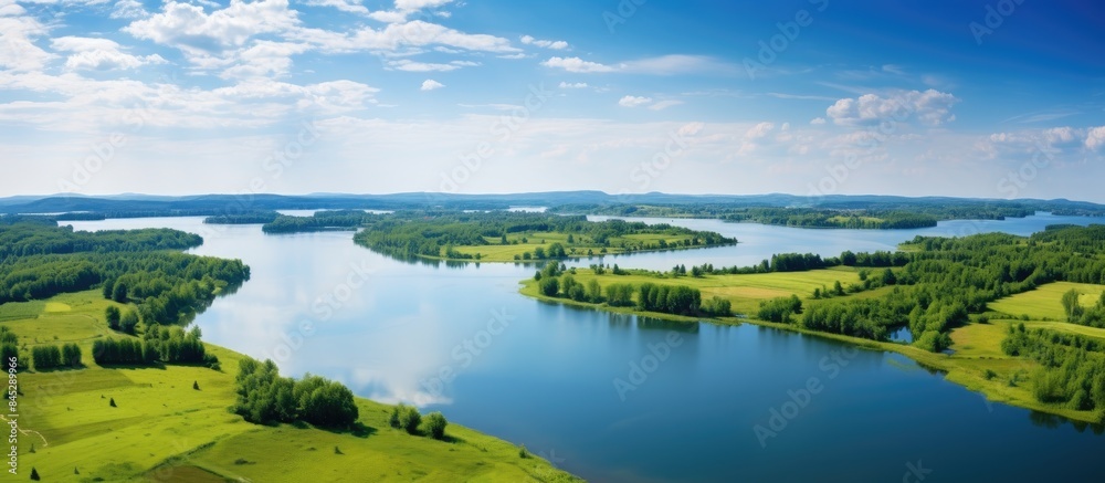 Drone captures top view of a stunning summer landscape with a serene blue lake nestled in a vibrant green field providing a picturesque nature background with ample copy space Drone captures top view of a stunning summer landscape with a serene blue lake nestled in a vibrant green field providing a picturesque nature background with ample copy space