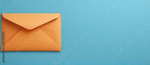 A mock up copy space image of a beige envelope with a blank orange sheet of paper inside is seen lying on a blue background The top view and flat lay perspective depict the concept of receiving mail photo