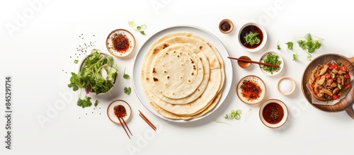 From an aerial perspective there is a copy space image of traditional Chinese tortillas filled with bings placed neatly on a white plate against a simple white backdrop On the same plate there are al photo