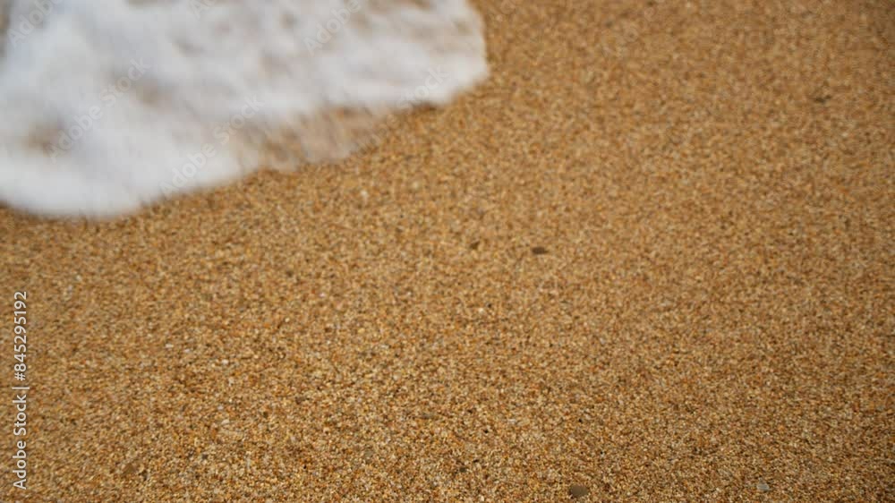 Foaming Wave Washes Over Orange Sand in Slow Motion Close Up Foaming Wave Washes Over Orange Sand in Slow Motion Close Up