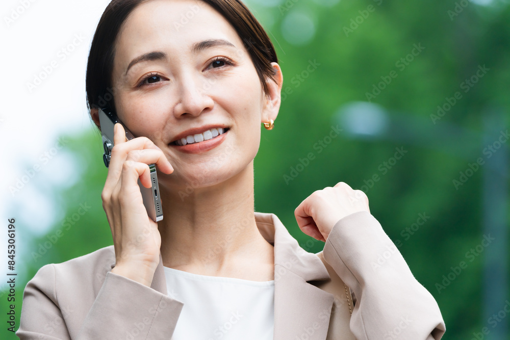 スマートフォンで通話している若い女性　ビジネスイメージ