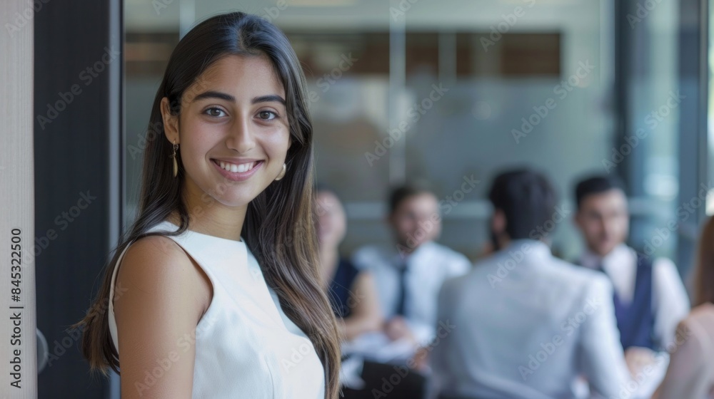businesswoman smiling while standing at the entrance to a boardroom businesswoman smiling while standing at the entrance to a boardroom