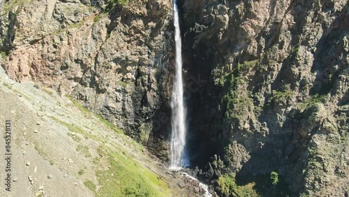 Smooth flight in the mountains above the waterfall. A powerful stream breaks down. Altay.