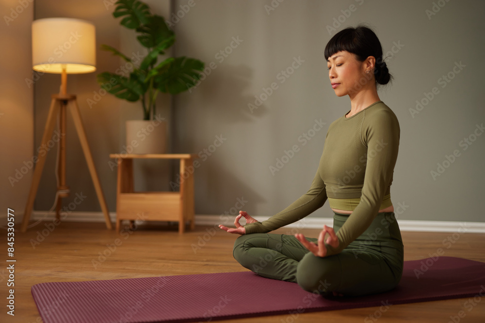 Beautiful Asian woman doing yoga or meditating at home Beautiful Asian woman doing yoga or meditating at home