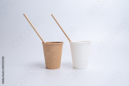 Top view of brown kraft paper cups, straws on a white background. Recyclable street food packaging. Zero waste. Paper dishes. Disposable takeaway cup 