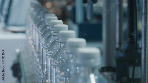 Water plastic bottles with caps transported by conveyor belt