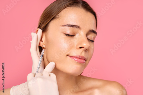 Fototapete A woman is receiving a facial treatment at a salon to achieve a glowing and yout