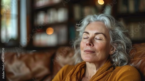 A smiling mature woman exudes tranquility with closed eyes, her serene expression visible