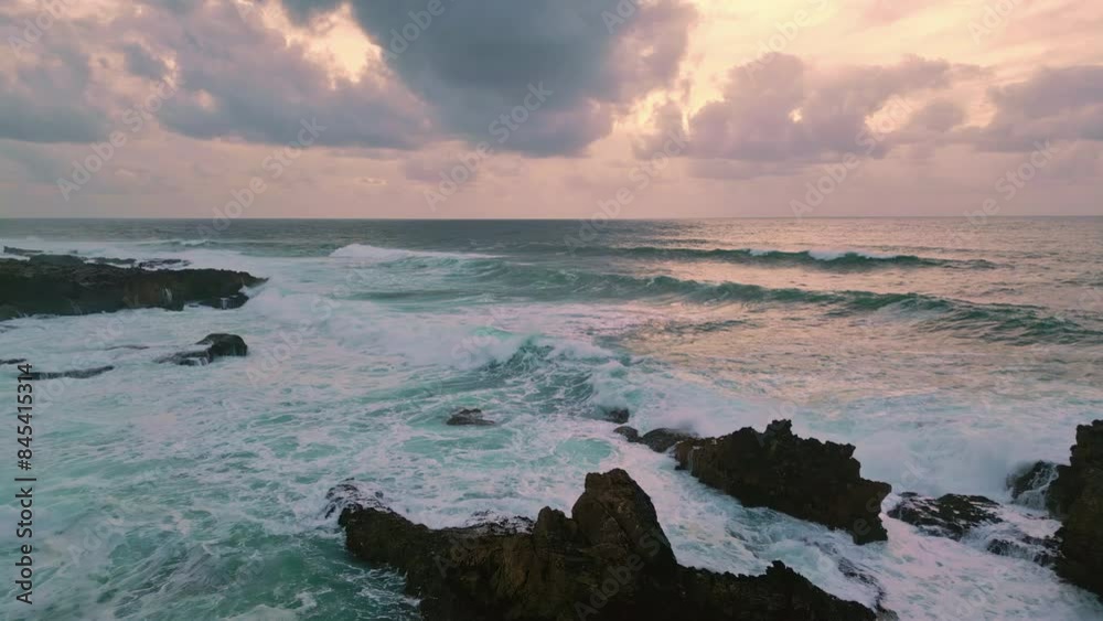 Panoramic view ocean waves under cloudy sunrise sky. Golden morning glow bathe Panoramic view ocean waves under cloudy sunrise sky. Golden morning glow bathe