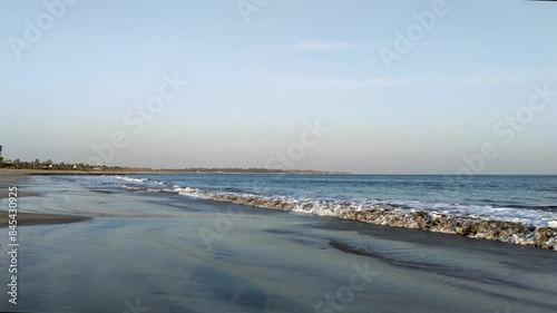 Slow motion of small waves of the sea arrive creating white foam on sand, on a clear day, Waves coming to the beach Shore, Full HD photo