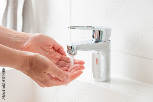 Sustainable use of natural resources banner. Clean tap water concept. Woman's hands with water near flow tap. Water running from chrome faucet. Using water resources concept, environmental protection
